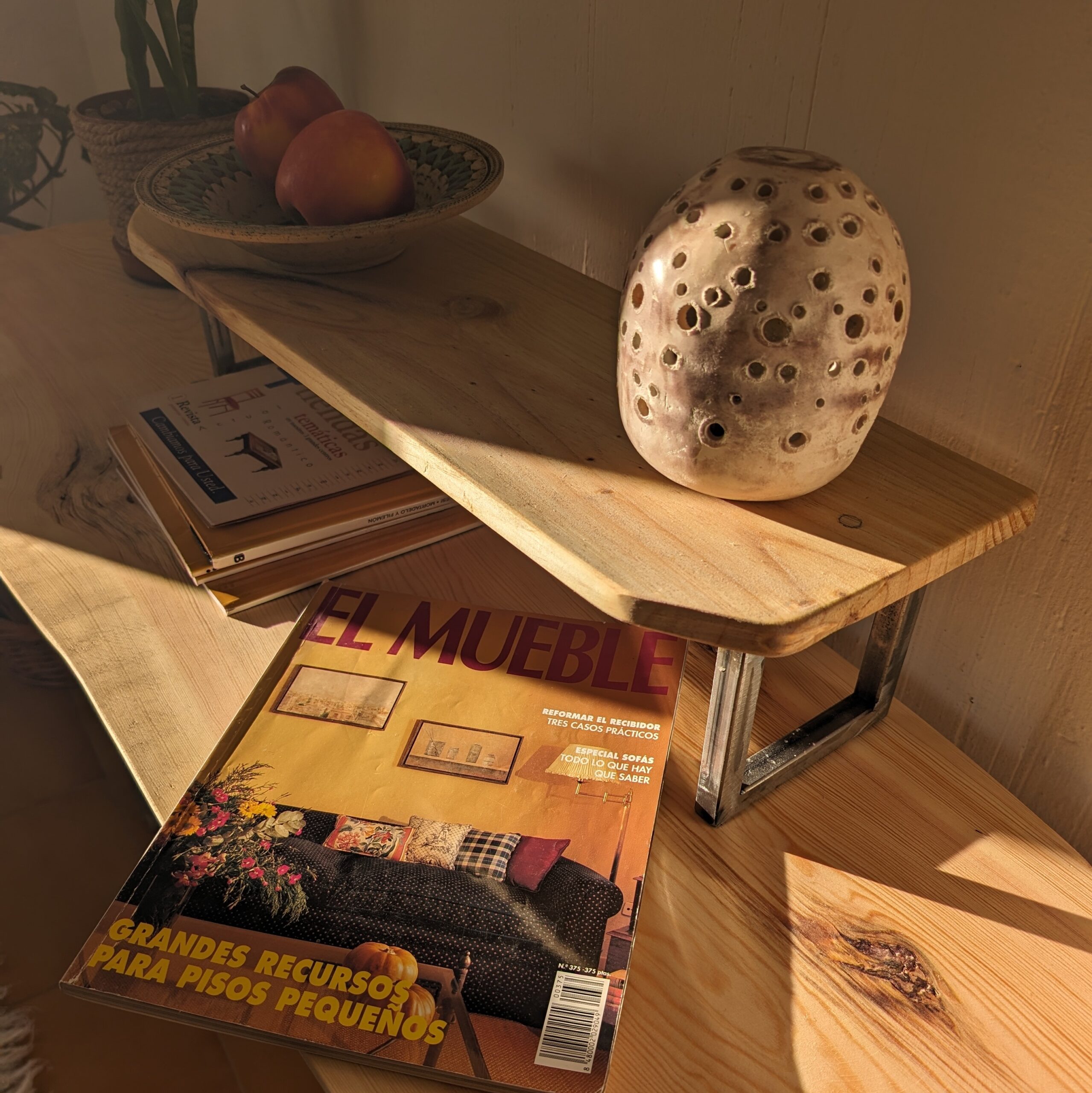 Golden hour sunlight. Console table with magazine and candle holder decoration